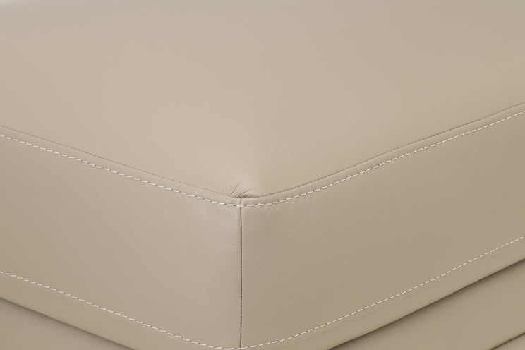 Close-up of beige leather furniture corner with stitching detail